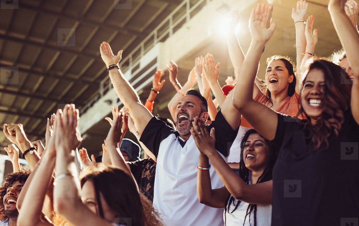 a group of people cheering in a stadium